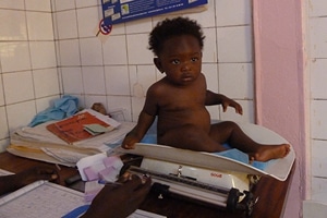 Très jeune garçon sur une balançoire pour la pesée au Burkina Faso