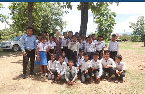 Photo d'Alexandra de Oliveira au milieu d'un groupe d'enfants de Krasang Primary School au Cambodge